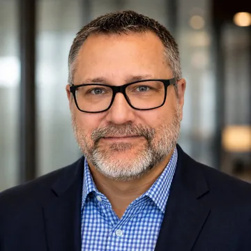 Scott Campbell, smiling, in glasses and a blue checked shirt